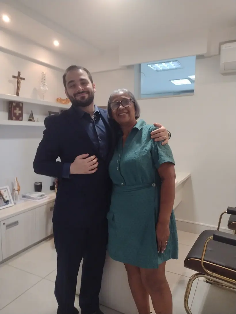Paciente ao lado do Dr. João Cláudio no consultório em Goiânia