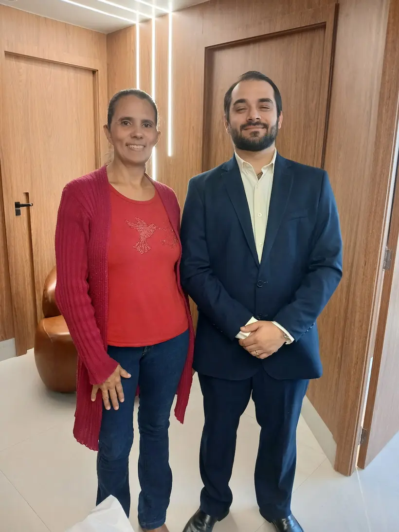 Dr. João Cláudio ao lado de uma paciente no consultório