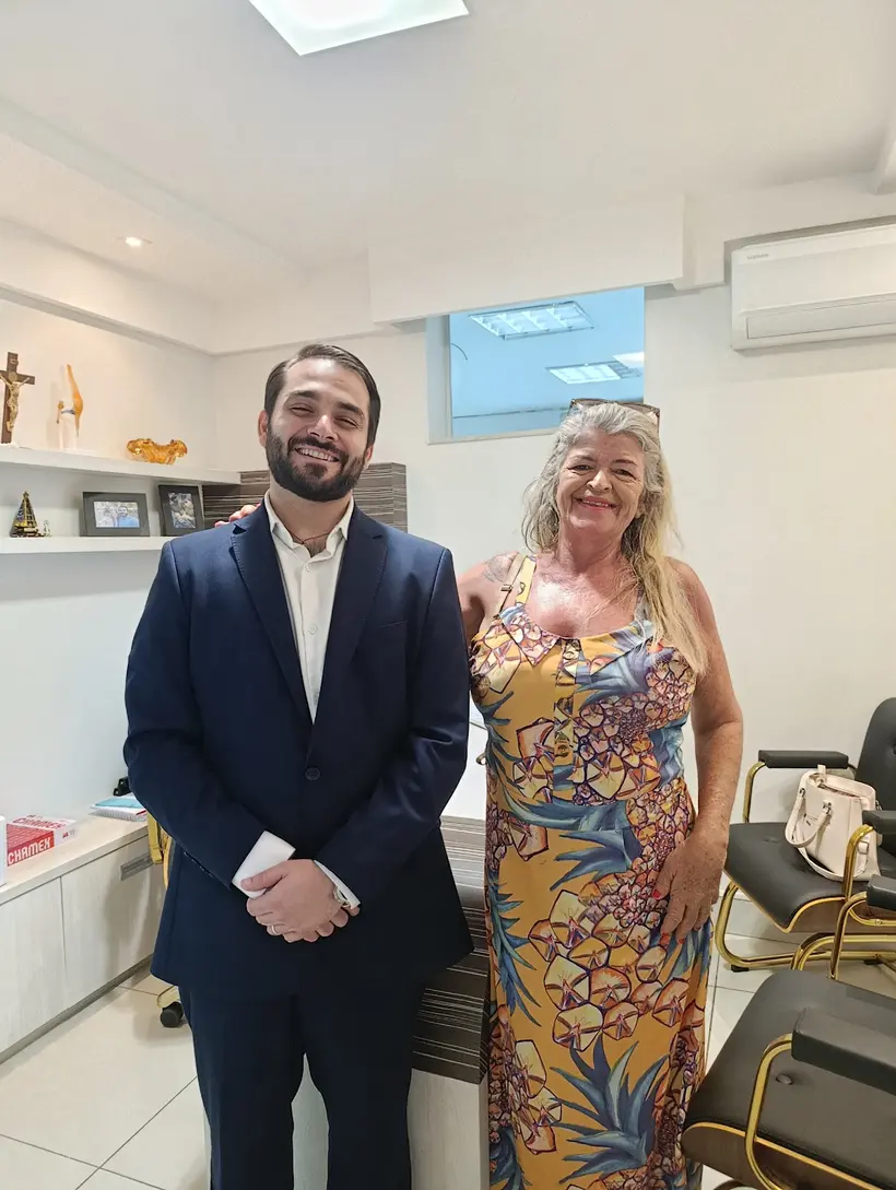 Paciente sorrindo ao lado do Dr. João Cláudio